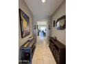 Stylish hallway featuring neutral paint, tile flooring, wooden furniture, and decorative wall art at 6516 W Madre Del Oro Dr, Phoenix, AZ 85083