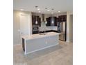 This spacious kitchen features a large island, stainless steel appliances, and dark wood cabinetry at 6516 W Madre Del Oro Dr, Phoenix, AZ 85083