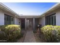 Inviting entryway with a brick pathway and lush greenery at 8631 E Vista Dr, Scottsdale, AZ 85250