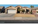House exterior featuring a large garage and well-maintained lawn at 9628 E Olla Ave, Mesa, AZ 85212