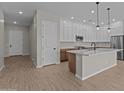 Modern kitchen with white cabinets, an island with pendant lights, and stainless steel appliances at 12316 W Parkway Ln, Avondale, AZ 85323