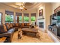 Spacious living room featuring a cozy fireplace and large windows at 14521 E Desert Vista Trl, Scottsdale, AZ 85262