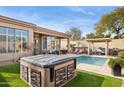 Inviting backyard oasis with a sparkling pool, spa, and covered patio at 15548 E Jojoba Ln, Fountain Hills, AZ 85268