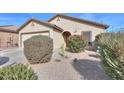 Tan colored house with a two-car garage and desert landscaping at 18489 N Davis Dr, Maricopa, AZ 85138