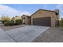 Single story home with a two-car garage and desert landscaping at 20249 W Woodlands Ave, Buckeye, AZ 85326