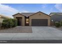 Single-story home with a two-car garage and desert landscaping at 20249 W Woodlands Ave, Buckeye, AZ 85326