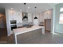 Spacious kitchen featuring white cabinets, a large center island, and stainless steel appliances at 21537 W Pierson St, Buckeye, AZ 85396