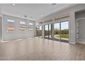 Bright open-plan living room with tile floors and sliding glass doors to the backyard at 21537 W Pierson St, Buckeye, AZ 85396