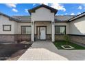 Front entry of a beautiful home with stone accents and landscaping at 23527 W Estes Way, Buckeye, AZ 85326