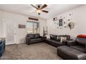 Living room with two leather sofas, an ottoman, and a ceiling fan at 23802 W Tamarisk Ave, Buckeye, AZ 85326