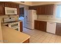 Traditional kitchen features wooden cabinets, white appliances, and neutral countertops and flooring at 25609 N Forest Rd # 20, Rio Verde, AZ 85263