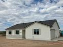 Single-story home with neutral exterior, dark roof, and stone accents at 25835 W Denver Hills Dr, Wittmann, AZ 85361