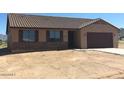 One-story home features a brown roof and stone accents at 25835 W Denver Hills Dr, Wittmann, AZ 85361