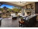 Relaxing outdoor patio features wicker furniture, a fireplace, and mountain views at 26698 N 104Th Way, Scottsdale, AZ 85262