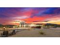 Stunning desert home exterior at sunset, featuring a large garage and manicured landscaping at 34709 N 48Th St, Cave Creek, AZ 85331