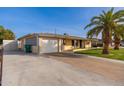 House exterior showcasing a driveway, garage and mature palm trees at 5452 E University Dr, Mesa, AZ 85205