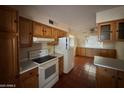 Bright kitchen with wood cabinets, tiled floor, and appliances at 5452 E University Dr, Mesa, AZ 85205