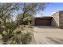 Front exterior showcasing stone facade and attached garage at 9909 E Lookout Mountain Dr, Scottsdale, AZ 85262