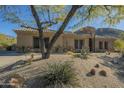 Tan house with stone accents, desert landscaping, basketball hoop at 14065 N 111Th Pl, Scottsdale, AZ 85255