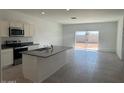 Open kitchen features granite countertops, an island with a sink, and sliding glass doors at 1419 W Hess Ave, Coolidge, AZ 85128