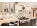 Gourmet kitchen featuring custom tile work, light countertops, stainless steel appliances and dark wood cabinets at 18805 E Loredo Ln, Rio Verde, AZ 85263