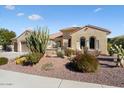 Inviting tan home with a three car garage, desert landscaping, and a charming patio area, perfect for outdoor living at 20369 N 272Nd Ave, Buckeye, AZ 85396