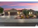 Inviting tan home with a three car garage, desert landscaping, and a charming patio area, perfect for outdoor living at 20369 N 272Nd Ave, Buckeye, AZ 85396