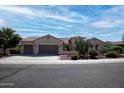 Tan stucco house with two-car garage, Southwestern landscaping, and a brown tile roof at 20369 N 272Nd Ave, Buckeye, AZ 85396