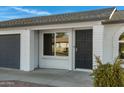 Front door entry with black security door and a gray garage door to the side at 10001 N 87Th Ln, Peoria, AZ 85345