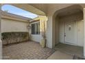 Inviting entryway with a paved patio and arched entry door at 10048 E Emerald Dr, Sun Lakes, AZ 85248