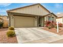 Beige house with a two-car garage and well-maintained landscaping at 1094 S 151St S Ln, Goodyear, AZ 85338