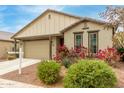 Single story home with beige exterior, red flowers, and a two-car garage at 1094 S 151St S Ln, Goodyear, AZ 85338