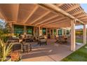 Relaxing patio area with covered pergola, comfortable seating, and dining at 14316 W Circle Ridge Dr, Sun City West, AZ 85375