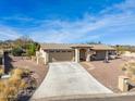 Tan house with a two-car garage, a walkway, and desert landscaping at 15212 N Palmetto Ln, Fountain Hills, AZ 85268