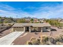 Single story home with a two car garage and mountain views in the background at 15212 N Palmetto Ln, Fountain Hills, AZ 85268