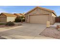 Tan house with tile roof, two-car garage, and desert landscaping at 2023 E Glenhaven Dr, Phoenix, AZ 85048