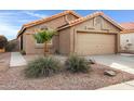 Tan house with tile roof, two-car garage, and desert landscaping at 2023 E Glenhaven Dr, Phoenix, AZ 85048