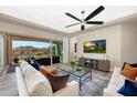 Bright living room featuring stylish furniture, ceiling fan, and a sliding glass door to outdoor patio at 20641 W Medlock Dr, Buckeye, AZ 85396