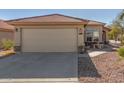 Tan house with a two-car garage and small front yard at 23205 W Arrow Dr, Buckeye, AZ 85326