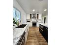 Bright kitchen featuring white cabinetry, stainless steel appliances, and a central island with a marble countertop at 2614 E Mountain View Rd, Phoenix, AZ 85028