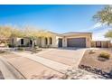 Tan colored house with brown garage doors and a landscaped front yard at 32807 N 15Th Gln, Phoenix, AZ 85085