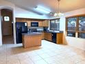 Well-lit eat-in kitchen with wood cabinets, granite countertops, an island, and modern appliances at 4043 E Arbor Ave, Mesa, AZ 85206