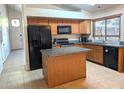 Kitchen features an island, wood cabinets, and modern appliances at 4043 E Arbor Ave, Mesa, AZ 85206