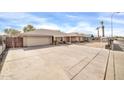 Front view of a single-story home with a large driveway at 7337 W Claremont St, Glendale, AZ 85303