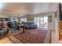 Living room with hardwood floors, large mirror, and access to balcony at 7930 E Camelback Rd # 509, Scottsdale, AZ 85251