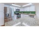 A close-up view of the stainless steel refrigerator, oven, microwave, and light granite countertops at 7930 E Camelback Rd # 509, Scottsdale, AZ 85251