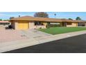 Brick ranch home with a large grassy yard and driveway at 9614 W Long Hills Dr, Sun City, AZ 85351