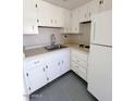 A cozy kitchen with white cabinets, appliances, sink and light countertops at 12221 W Bell Rd # 259, Surprise, AZ 85378