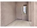 Close-up of the tan front door featuring a vertical window and a tan stucco wall at 1699 E Hearne Way, Gilbert, AZ 85234