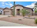 Charming single-story home featuring a three-car garage and desert landscaping with cacti and gravel at 1699 E Hearne Way, Gilbert, AZ 85234